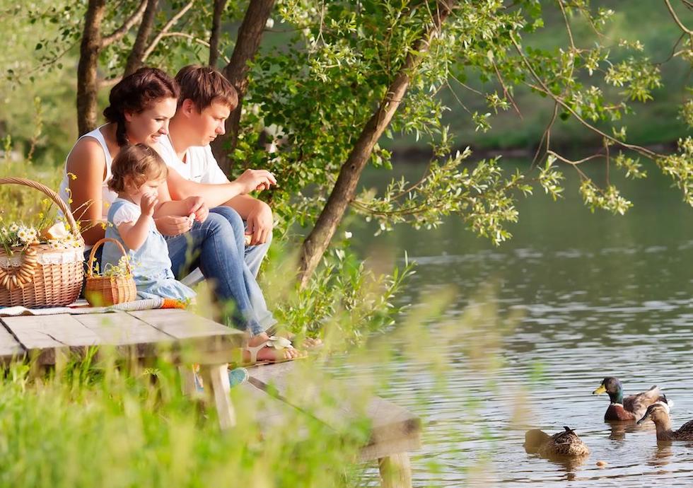 parents with the child on the lake