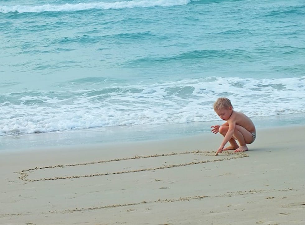 child playing in the sand