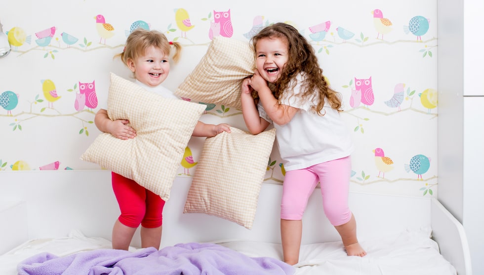 Kids playing with pillows while wearing pyjamas