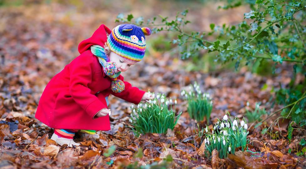 Little girl playing with flower in the park